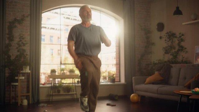 Strong Athletic Fit Senior Man Doing Cardio High Knees And Core Strengthening Exercises During Morning Workout At Home In Sunny Apartment. Fitness And Recreation Concept. Zoom Out Shot.