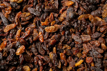 a lot of raisins. Raisins texture as background. Closeup grape raisin on a tray. lots of dried...