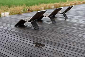 Chaises longues en bois sur terrasse pluie