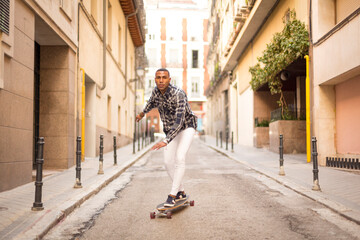 Fototapeta na wymiar young african american man rollerblading with long board on the street
