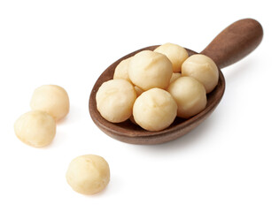 Shelled Macadamia nuts in the wooden spoon, isolated on white background.