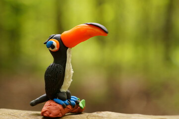 A toy toucan with an orange beak close-up. Tropical birds.