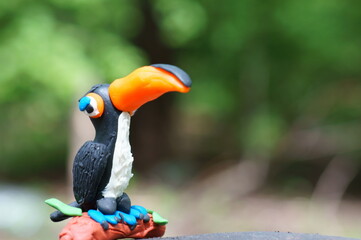 A toy toucan with an orange beak close-up. Tropical birds.