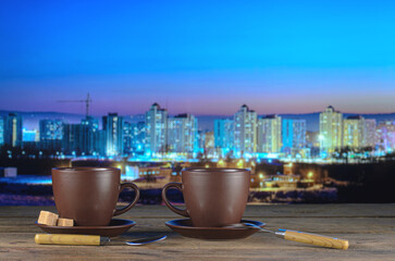 Two cups of tea against the backdrop of a winter night city