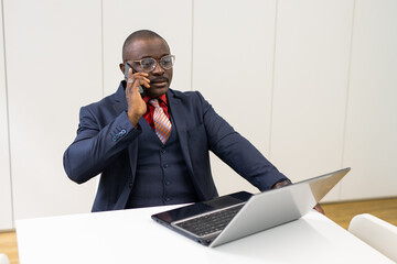 phone call of working african businessman with laptop