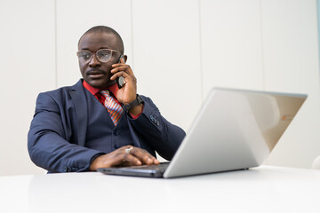 phone call of working african businessman with laptop