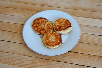 Homemade cheesecakes on a plate on the wooden background