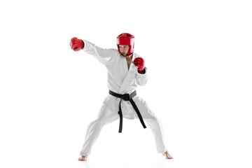 Fototapeta na wymiar Portrait of young sportive man wearing white dobok, helmet and gloves practicing isolated over white background. Concept of sport, workout, health.