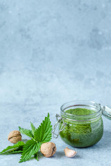 Vegetarian nettle, garlic and walnut pesto. jar of homemade nettle pesto with walnuts and garlic. Vegan nettle pesto