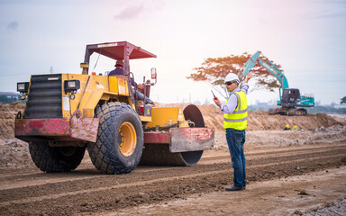 Surveyor engineer wearing safety uniform ,helmet and radio communication with equipment theodolite...