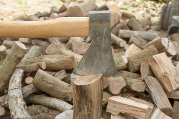 The ax lies on the wood. Firewood chopping. Preparation of firewood for the winter.