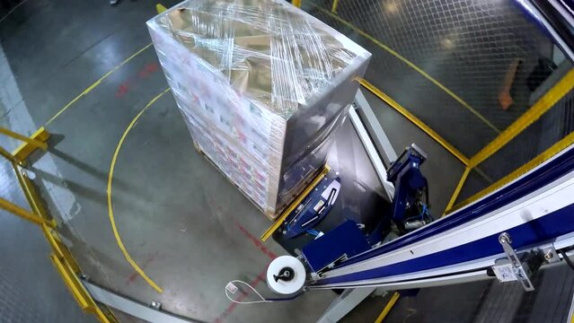 Box stretch wrapping machine timelapse. pallet wrapping machine. Machine for wrapping boxes in a plastic film in a circle. Packing boxes in plastic film.