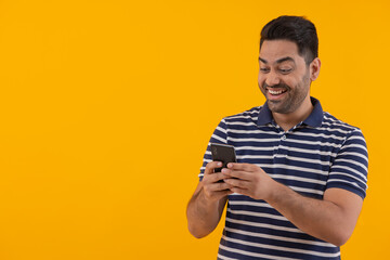 Portrait of happy young man having fun while using Smartphone