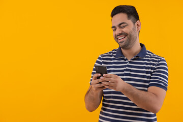 Portrait of happy young man having fun while using Smartphone