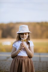 Dziewczynka trzyma w dłoni bukiet kwiatów - obrazy, fototapety, plakaty