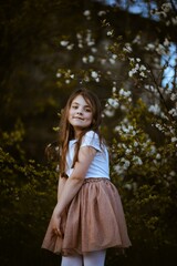 Radosna dziewczynka przy drzewach jabłoni  - obrazy, fototapety, plakaty