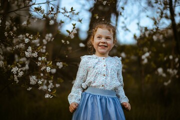 Radosna dziewczynka przy drzewach jabłoni 