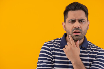 Fototapeta premium Portrait of surprised man with hand on chin