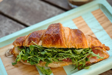 Delicious fresh French croissant with prosciutto, provolone cheese, arugula, tomato and vegetables served with affogato coffee
