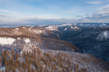 Aerial top view city Krasnoyarsk Russia taiga forest and rocks of stolby sanctuary, winter sunset