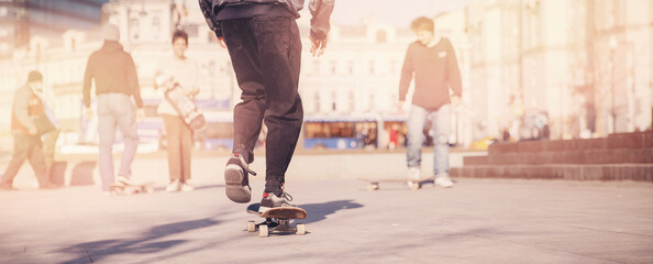 Man young skateboarder legs skateboarding skatepark on sunset. Concept tricks and jumping on...