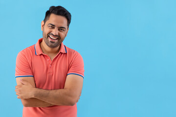 Portrait of a smiling young man looking at camera with hands folded