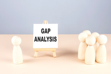 GAP ANALYSIS text on easel with wooden figure, meeting concept