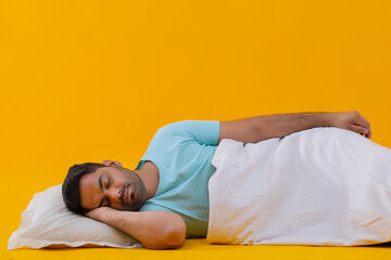 Portrait of a young man sleeping covered with a blanket