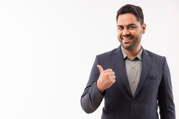 Portrait of a cheerful young businessman in formal outfit pointing sideways