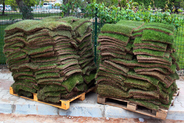 Stacks of green sod patches, used for grass lawn making