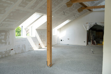 Construction site of attic conversion in the phase of floor screed fill and drywall is already in...