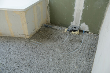 Construction site of attic conversion in the phase of floor screed fill and drywall is already in place and already partially spackled