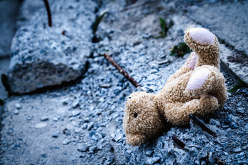 Conceptual image: Russia's war against Ukraine. A pile of construction debris and children's toy teddy bear. Copy space.