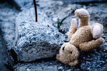 A pile of construction debris and children's toy teddy bear.