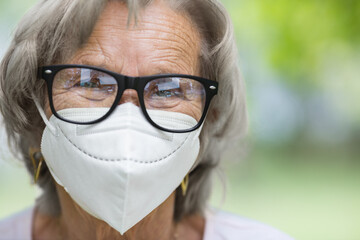 Elderly woman wearing a protective face mask against viruses