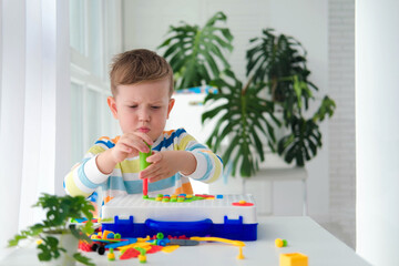 Little boy playing set with a screwdriver and a drill,  and screws and parts . The child plays...