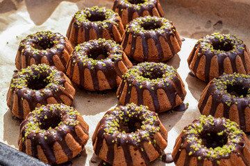 Small decorative pastries topped with chocolate and pistachio nuts