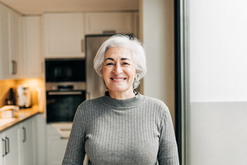 Carefree senior woman smiling at the camera at home