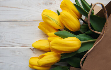 Bouquet of yellow tulips in a kraft paper bag