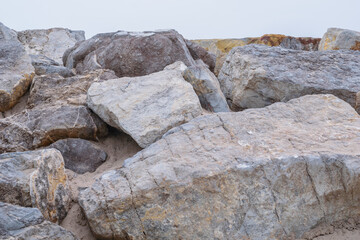 Photos of stones and beach rocks, where you can see their textures, lines, shapes, colors, humidity, crabs, the photos were taken on a cloudy day with a cold tone and white balance.