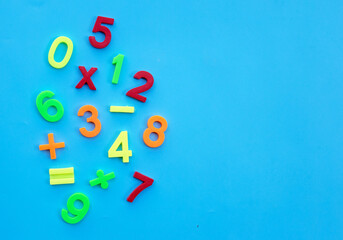 Colorful plastic digits or numbers on blue background.