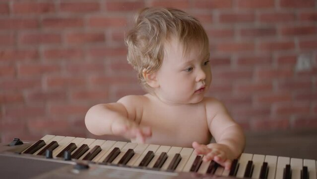 Asian Baby Girl Toddler Playing Electric Piano, Sit Down On The Floor Tapping On Keyboard Music Instrument, Kids Artistry Learning Skills, Happy Healthy Female Child Pretend To Play Music By Herself