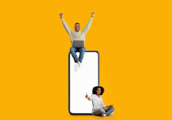 Black couple showing white empty smartphone screen and gesturing yes