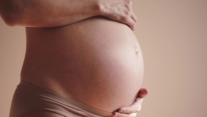pregnant woman. health pregnancy motherhood procreation concept sunlight. close-up belly of a pregnant woman. woman waiting for a newborn baby. pregnant woman holding her belly indoors