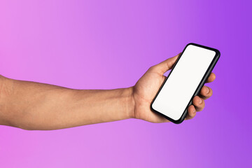 Cropped view of millennial man holding cellphone with empty white screen in neon light, mockup for mobile app or website