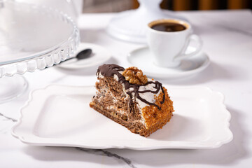 A piece of dessert on a white plate on a white marble table