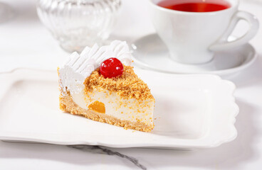 A piece of dessert on a white plate on a white marble table