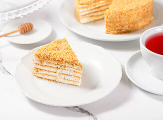 A piece of dessert on a white plate on a white marble table