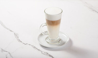 Glass cup with latte on marble white table