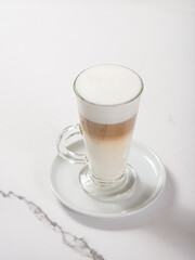 Glass cup with latte on marble white table